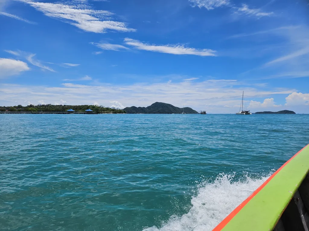 Ruhiges türkisblaues Meer mit Inseln und Segelboot als Bild für die Ruhe, die nach einer EMDR-Behandlung wieder möglich wird.