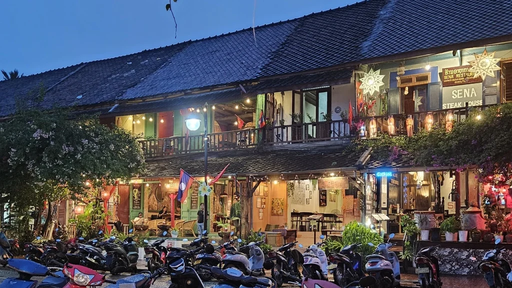 Abendszene in Südostasien mit beleuchteten Restaurants und Laternen, symbolisch für die Möglichkeit, von überall einen Psychotherapeuten online zu finden
