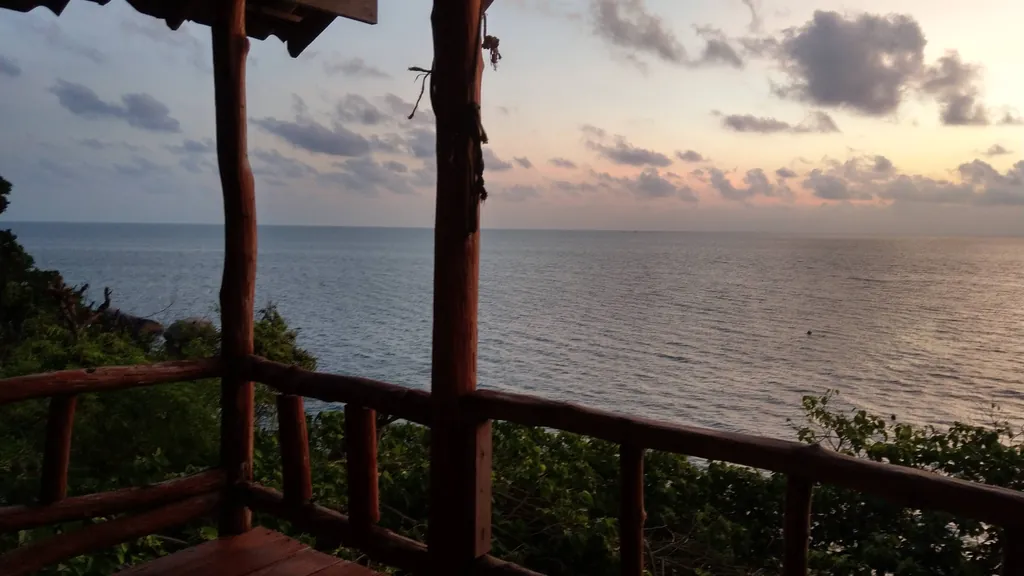 Blick von einem Holzbalkon auf das Meer in der Abenddämmerung